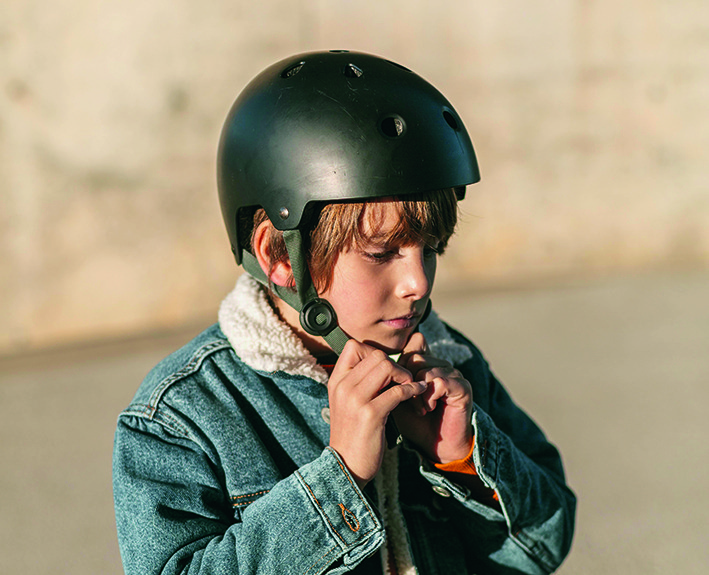 Enfant attachant son casque avant de monter à vélo.