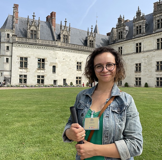 Roxane pose devant le château royal d'Amboise, où elle est guide-conférencière.