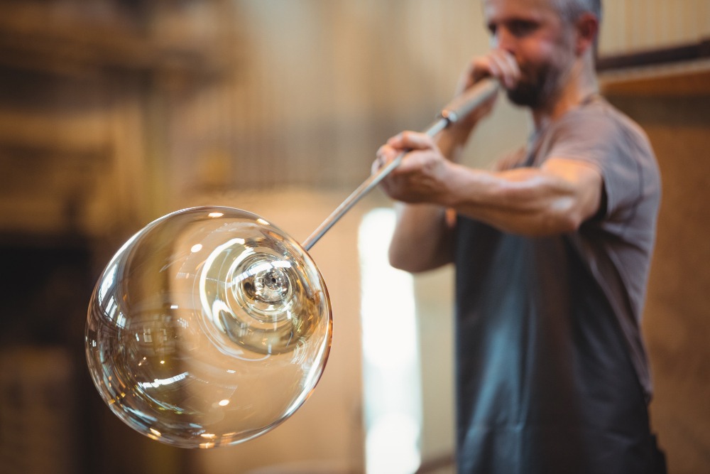 Photo d'un homme en train de souffler le verre (crédit photo Freepik).